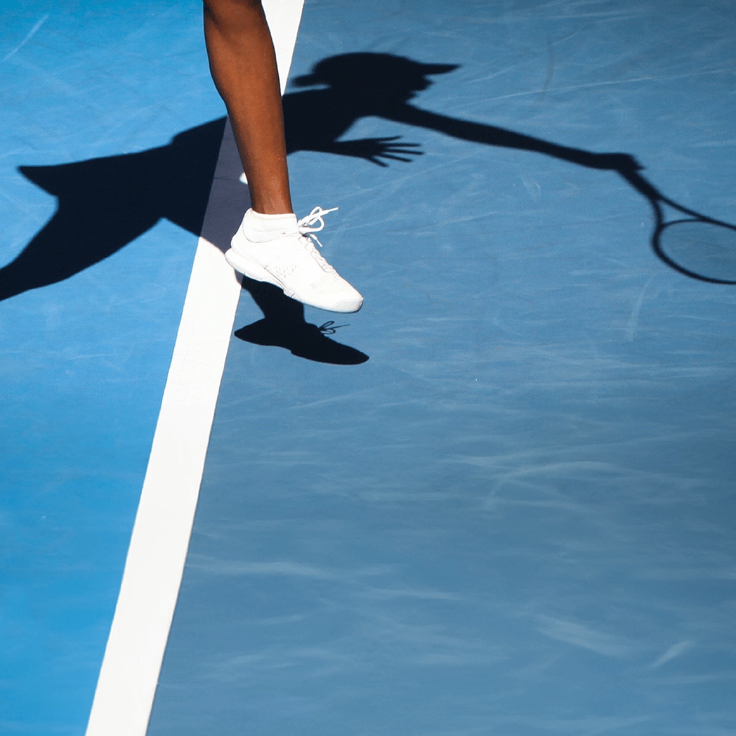 Shadow of a tennis player making a serve